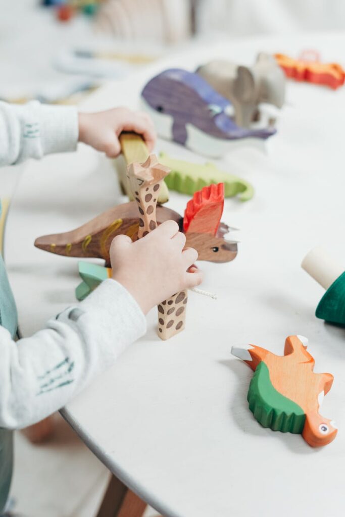 Photo by cottonbro studio A young child creatively plays with colorful wooden toys on a table, fostering imagination and learning.