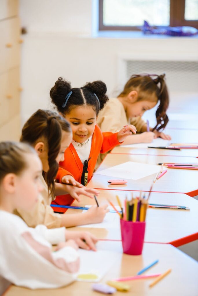 Photo by Anastasia Shuraeva Joyful children drawing and learning in a bright, lively classroom setting.