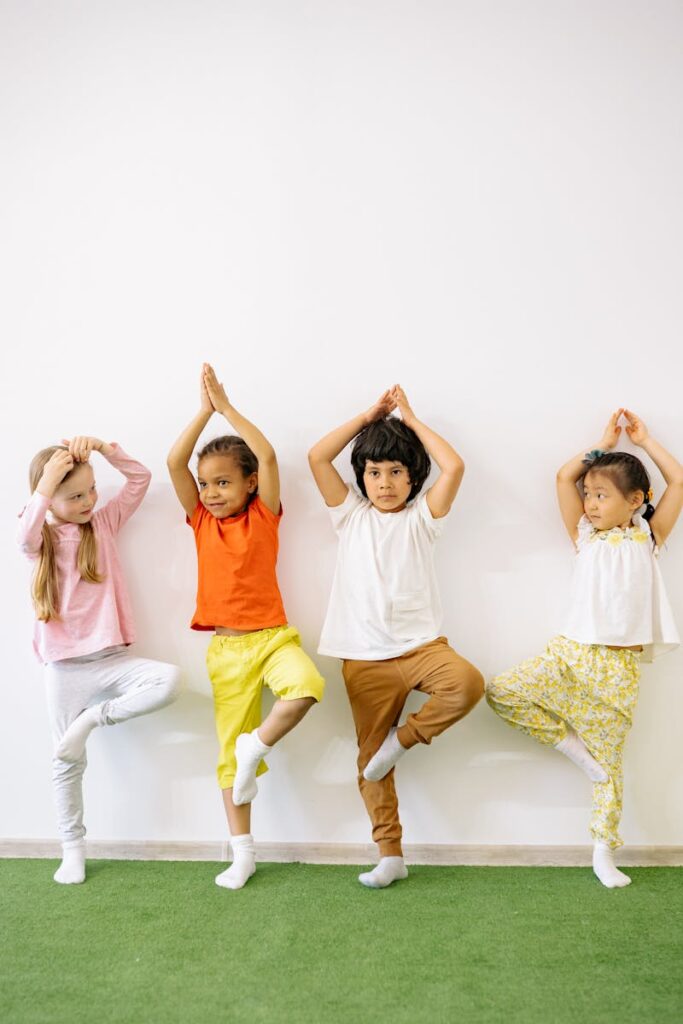 Photo by Yan Krukau Four diverse children practicing yoga indoors, promoting fun and exercise in a learning environment.
