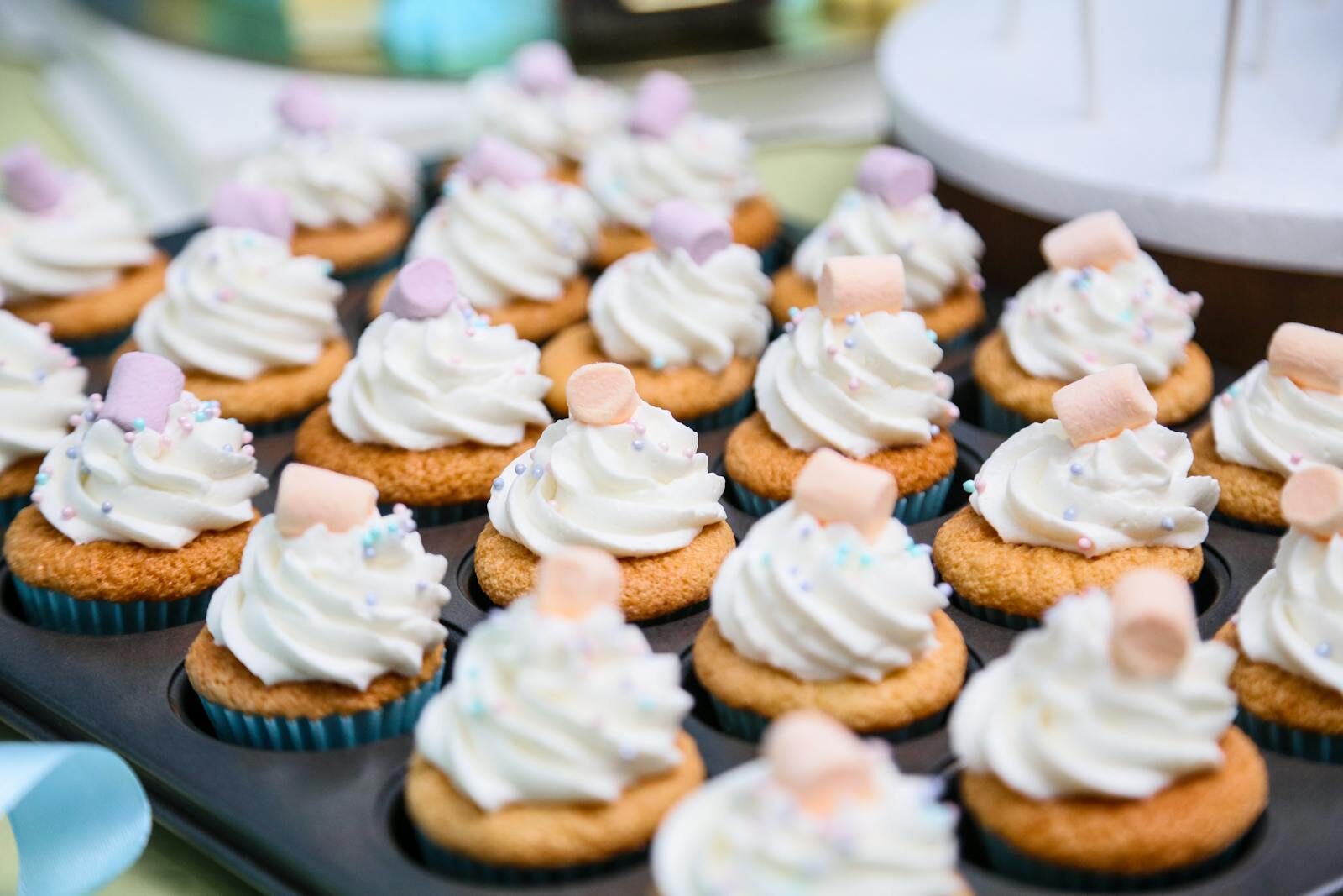 Close-up of cupcakes topped with whipped cream and marshmallows, perfect for dessert cravings.